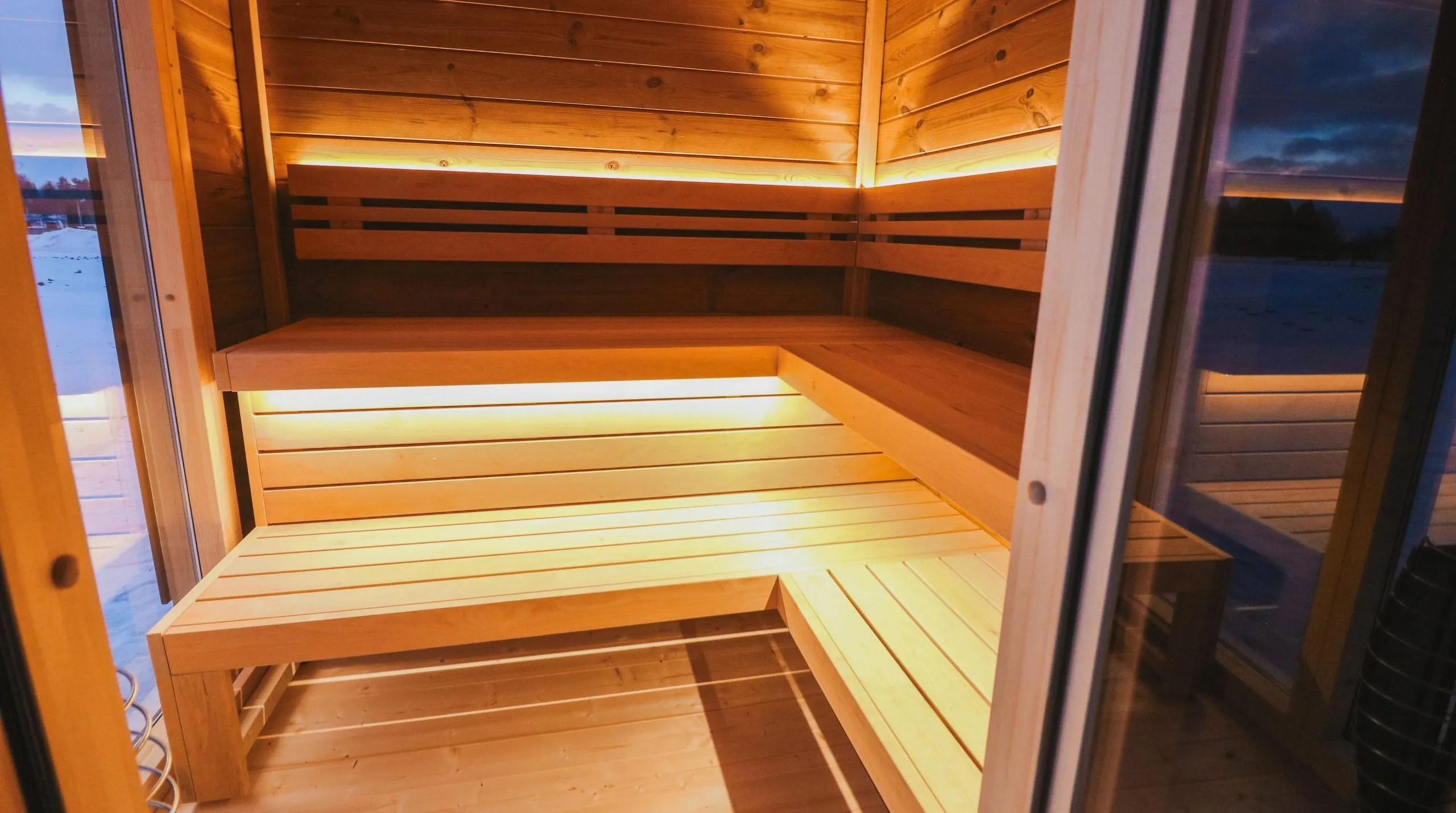 Les banquettes intérieures en bois et illuminées par des leds dans le sauna Gotland L
