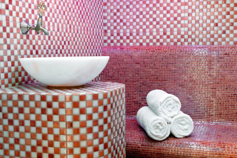 Robinet et serviettes dans un Hammam en mosaïque.
